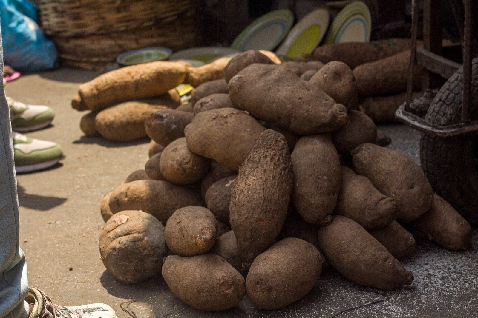 A heap of harvested yams piled at a market stall.