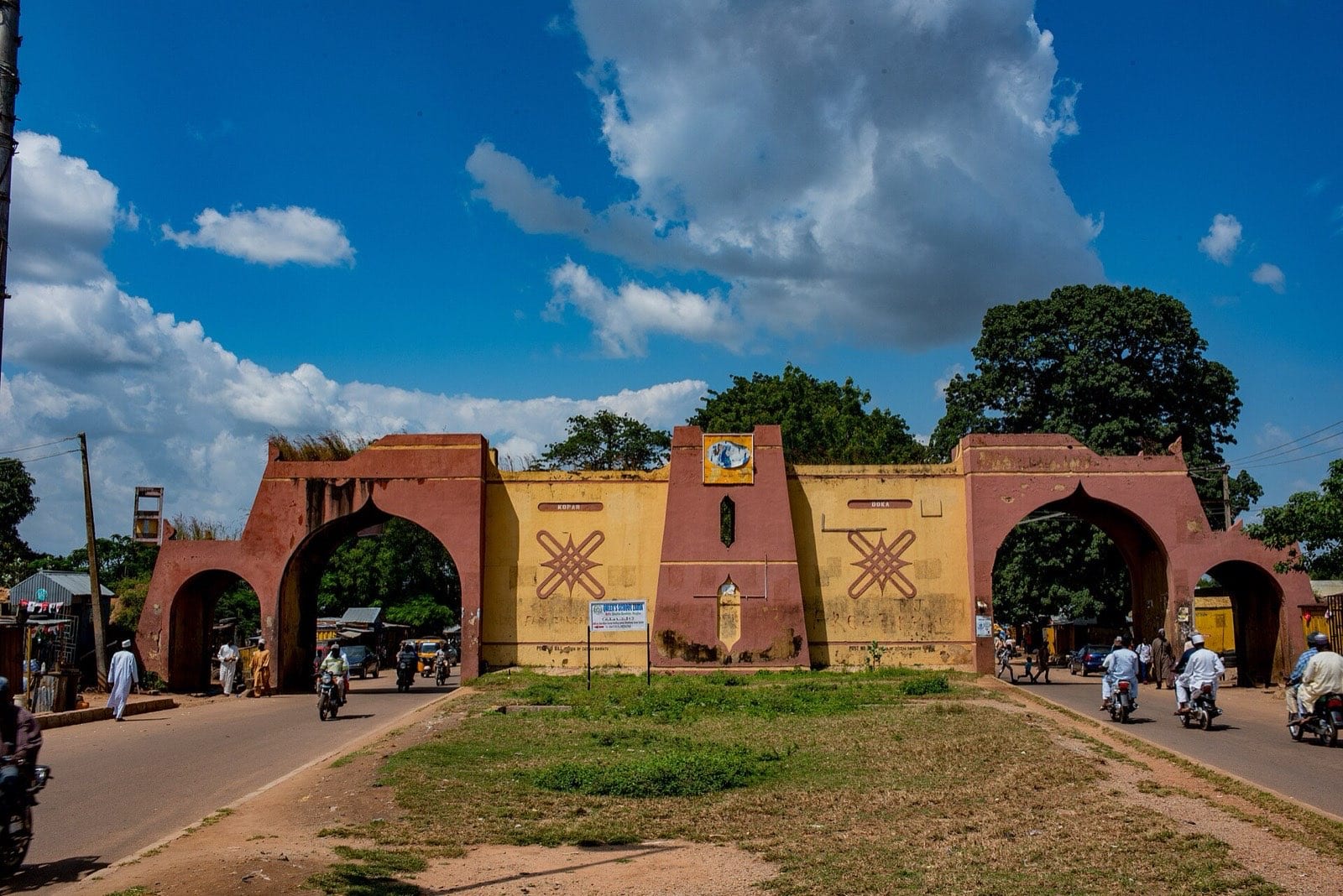 A restored city gate in the earth wall at Zaria, with the road running through it.