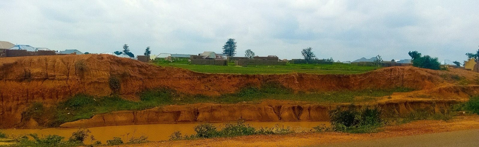 A long stretch of collapsed earth wall running across open ground.