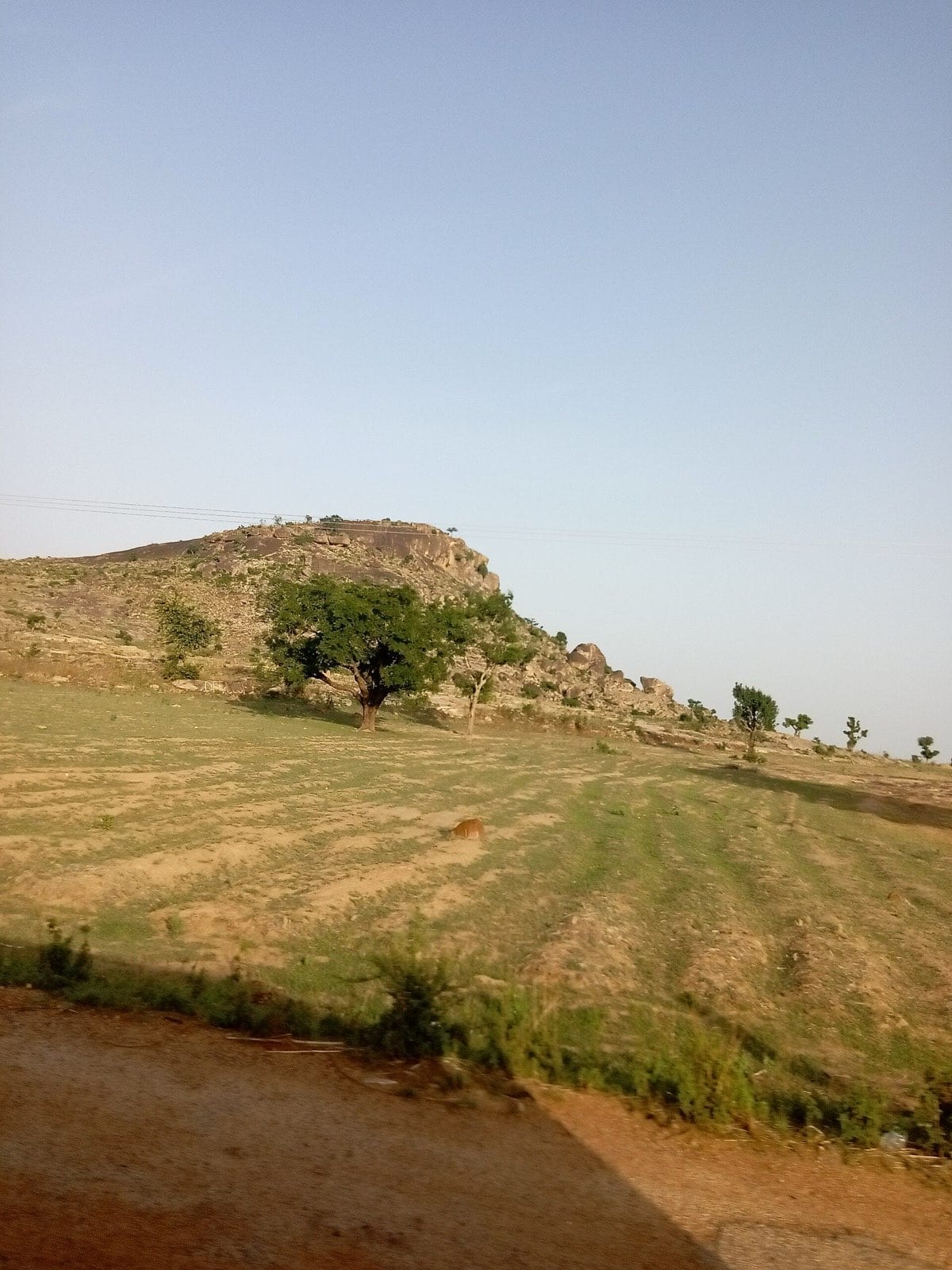 A rocky hill rising above scrub on the Jos plateau.