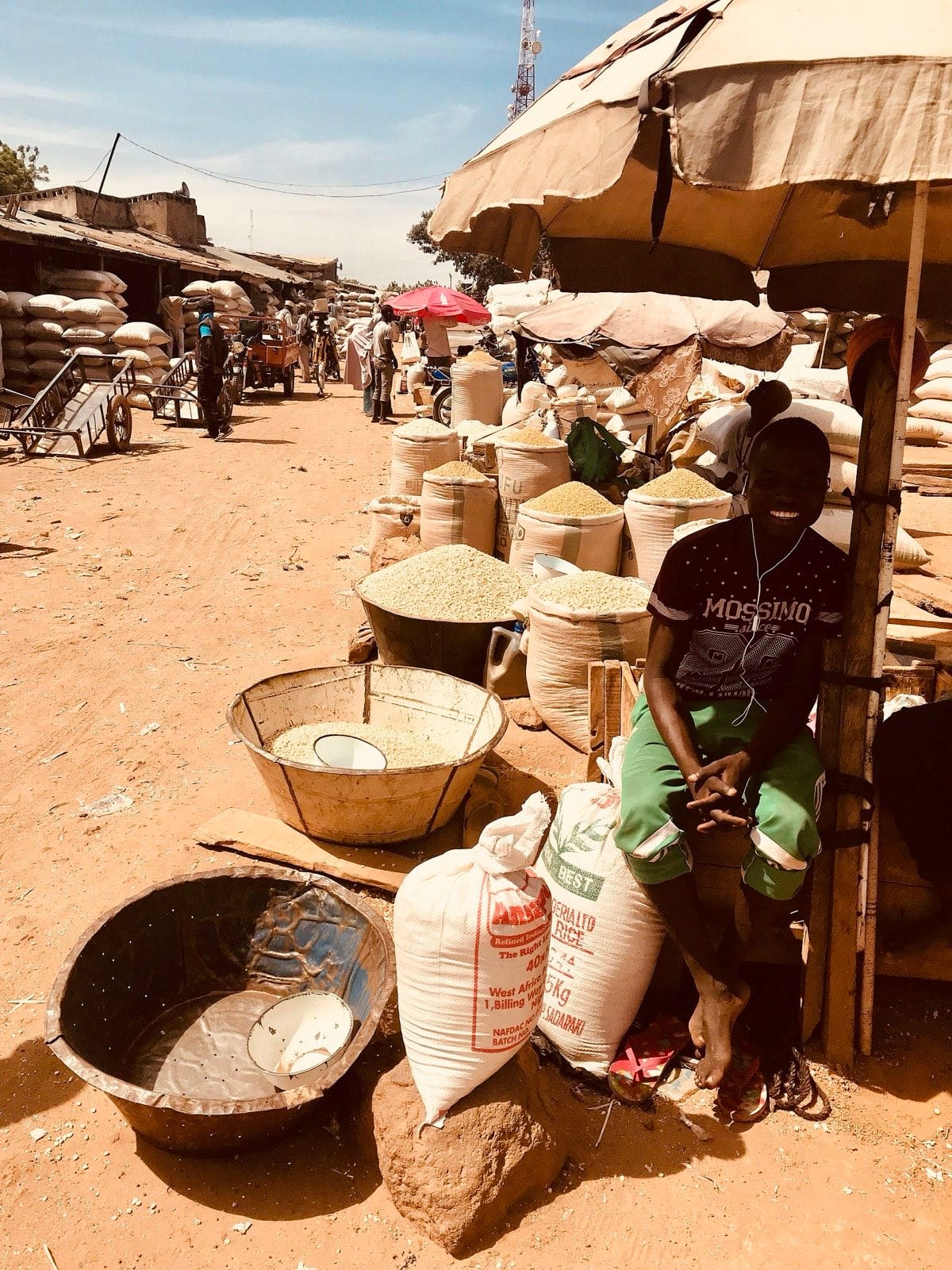 Traders and sacks of grain filling a crowded open-air market.