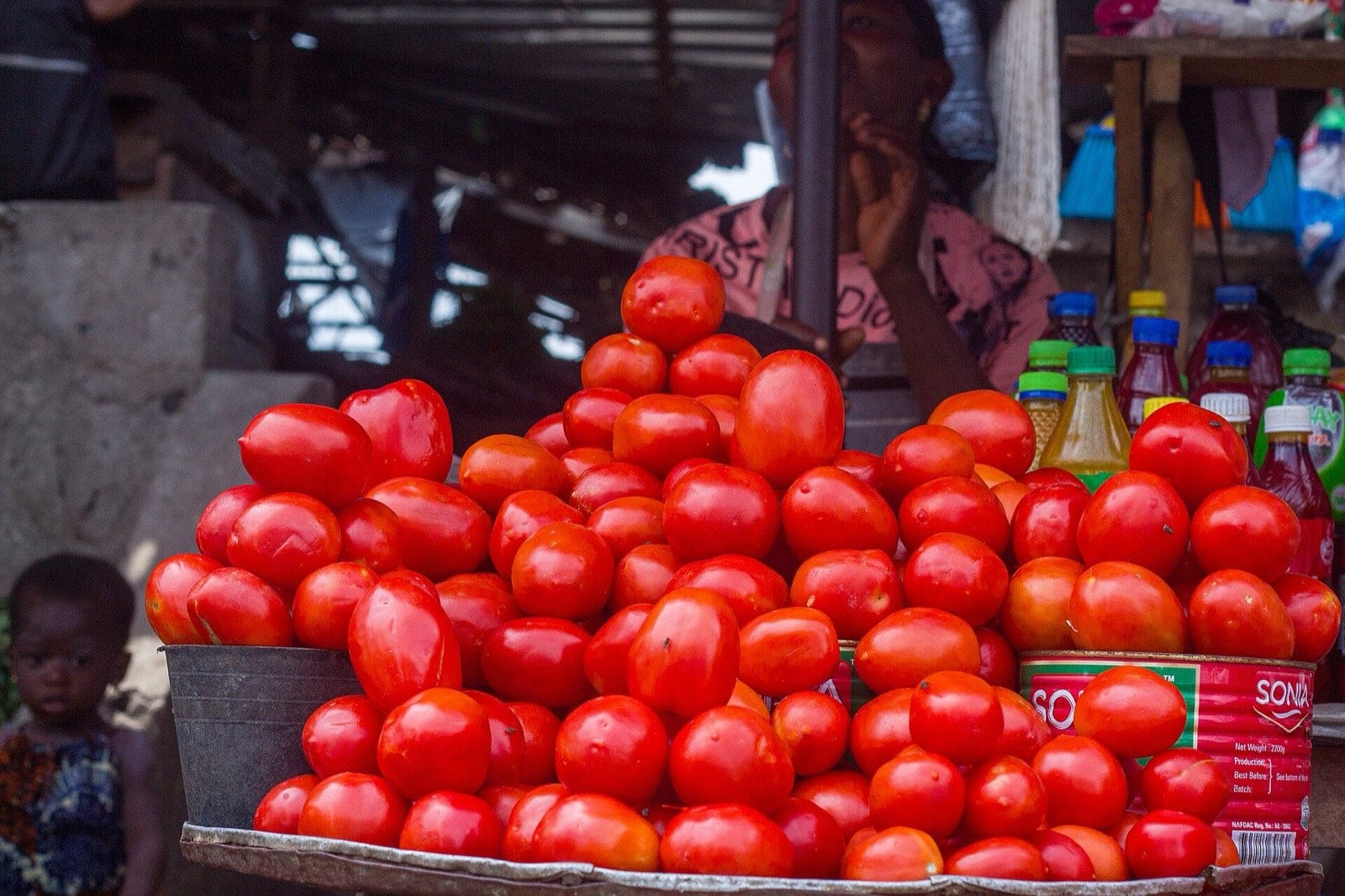 A pile of ripe tomatoes stacked at a market stall.
